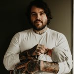 man in white crew neck t-shirt with tattoo on arm