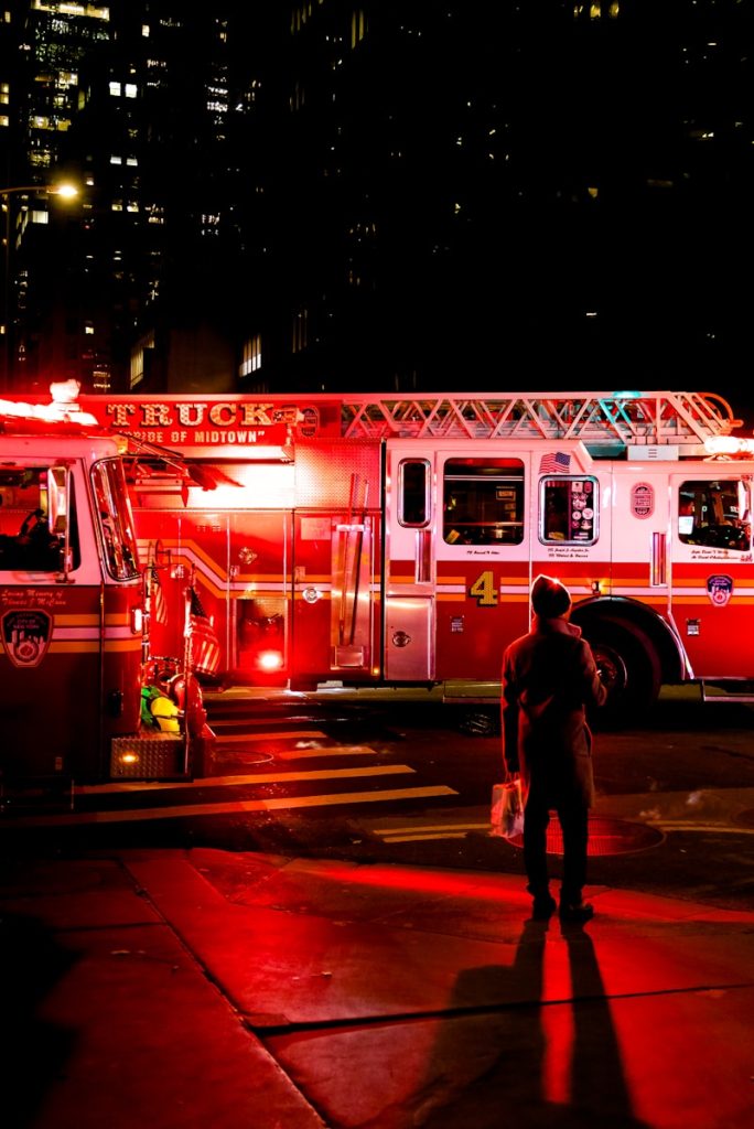 person standing near lighted firetruck
